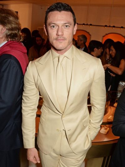 Traje beige liso solapa pico vestido por Luke Evans